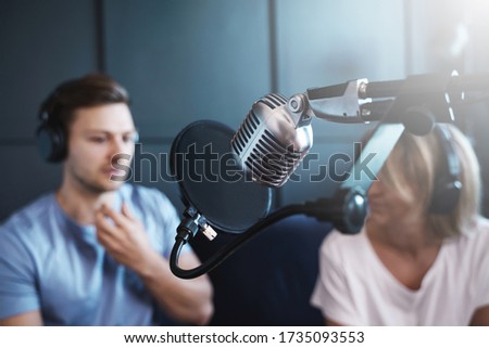 Man and woman recording podcast or interview in the cosy studio