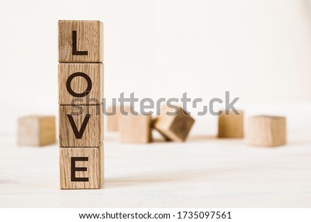 Love message written in wooden blocks on light background