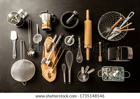 Kitchen utensils (cooking tools) on black chalkboard background. Kitchenware collection captured from above (top view, flat lay). Royalty-Free Stock Photo #1735148546
