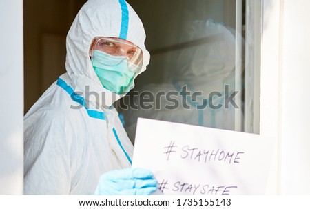 #stayhome #staysafe Message held by employees at the entrance to a clinic during a coronavirus pandemic