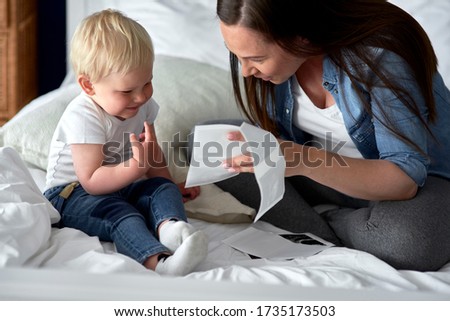 Curious toddler watching pictures of his future sibling