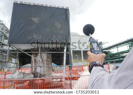 Hand of Environmental officer holding to use sound level meter for monitor is part of the prevention of environmental impacts at Chemical plant area or refinery factory. Royalty-Free Stock Photo #1735203011
