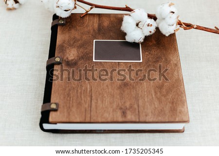 Luxury wooden photo book on linen natural background. Family memories photobook. Save your summer vacation memories. Photo album wedding photoalbum with wooden cover.