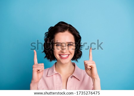 Closeup photo of attractive lady short black hairdo good mood direct fingers up empty space advising novelty product shopping wear casual pink denim jacket isolated blue color background