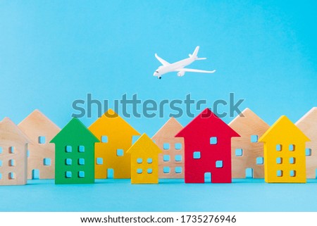 Art design picture of nice wooden figures settlement city residence economy development plane flying isolated over bright vivid shine vibrant blue color background