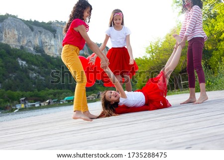 Group of preteen kids have fun outdoors in the nature and playing games together