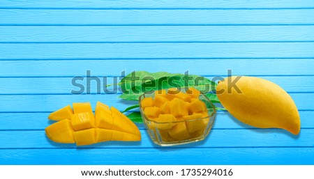 Yellow ripe mangoes on a blue wood floor with clipping paths.
