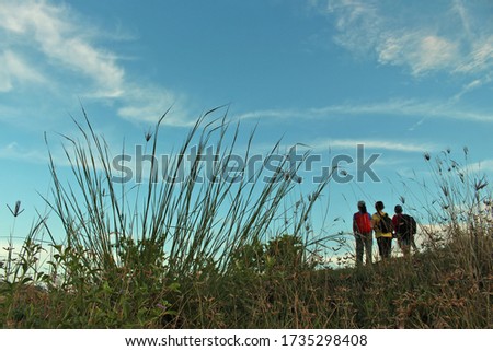 Meadow background and  blurry happy young women standing against blue sky. Friendship and travel together with best friends concept.