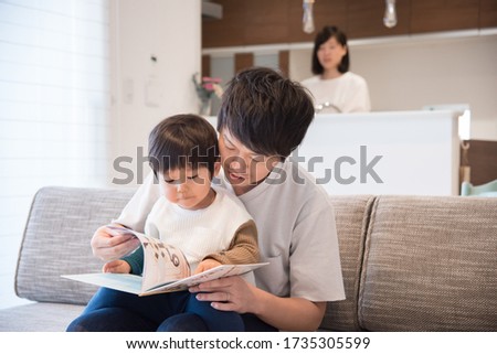 Father reading a book in the living room
