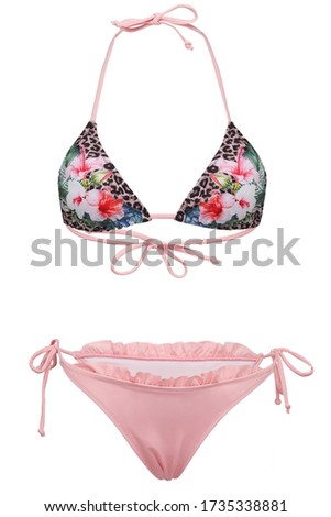 Detailed shot of a two-piece swimsuit consists of pink bikini with a fril and a triangle bra with thin straps, leopard pattern and printed flowers. The swimsuit is isolated on the white background.