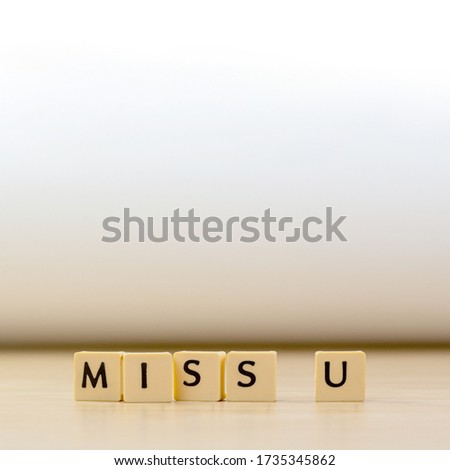 miss you word written in  cube on wooden floor on white background, letter blocks arranges into MISS U words, for adding text or other images or design