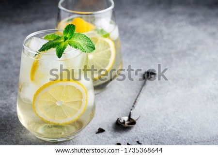 cold sparkling green tea with lemon, mint and ice, glasses on a grey background, summer drinks, lemonade Royalty-Free Stock Photo #1735368644