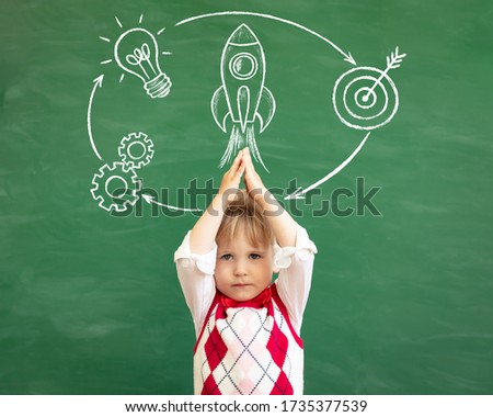 Funny child student in class. Happy kid against green chalkboard. Physical education concept. Back to school