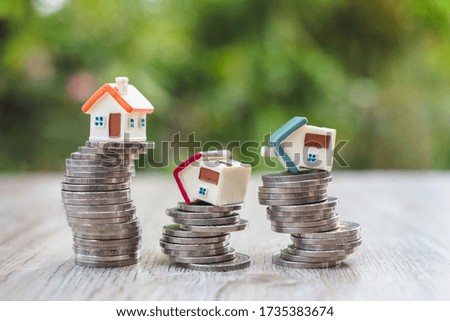 A house on a pile of coins that is about to fall Ideas for investment that may be at risk Choosing to invest in a residential business during the time period.