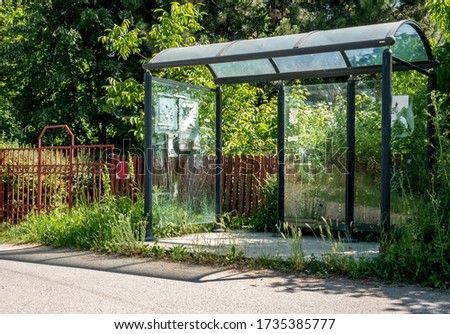 Old abandoned bus stop with broken glass, on the side of the road