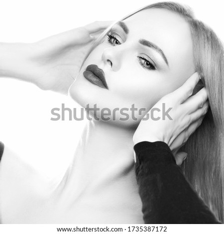Beautiful fashion model Woman with blond hair, Bright lipstick makeup, hands near head. Monochrome