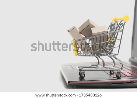 A lot of paper boxes in a small basket on a laptop keyboard. Concepts about online stores that consumers can buy right at home or in the office using the website