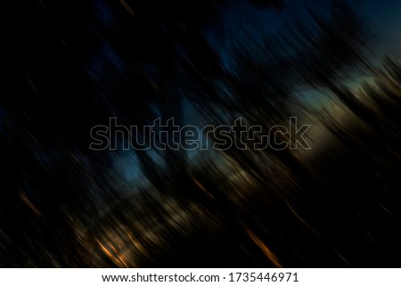Bushfire starting in surreal silhouetted hazy forest at dusk - abstract motion blurred background, texture