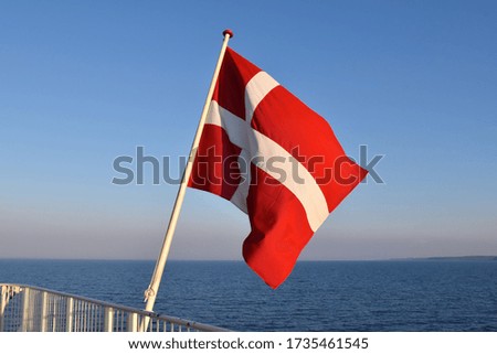 Danish flag on a ship sailing on the blue water