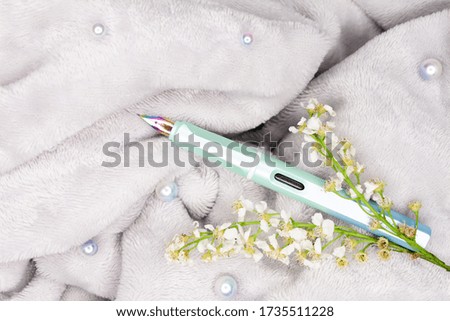 A fountain with pearls and blossoms on gray background
