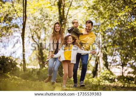  Life is simple when you love your family. Parents spending time with their children outside. Focus is on foreground. Royalty-Free Stock Photo #1735539383