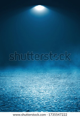 Dark dramatic abstract scene background. Searchlight reflection on the pavement. Smoke, smog and fog