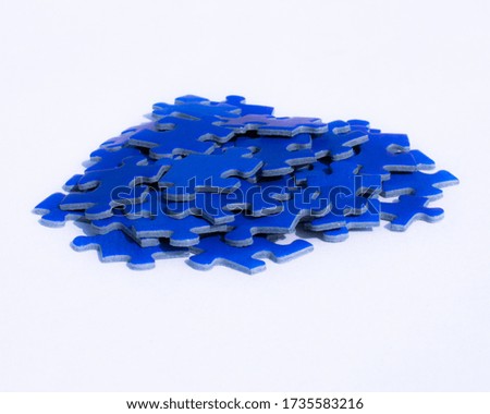 A pile of blue puzzle jigsaw pieces.