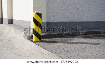 security pylon in a parking against shop facade