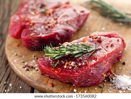 Raw beef steak on a dark wooden table. Royalty-Free Stock Photo #173560082