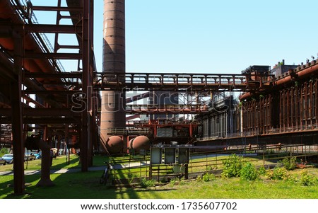 The old and disused former coking plant and coal mine with the name Zollverein, translated means toll society. The place is located in North Rhine-Westphalia in the city of Essen. Sun and blue sky. Royalty-Free Stock Photo #1735607702