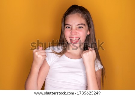 Beautiful teenager girl happy and excited expressing winning gesture. 