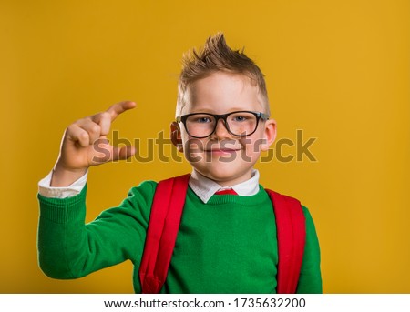 Happy kid showing size of something.  Smiling boy showing space between fingers