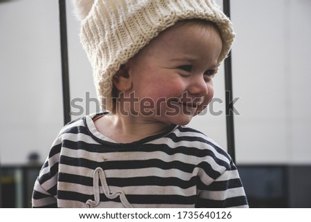 A shallow focus shot of a cute little baby in a white knitted winter hat