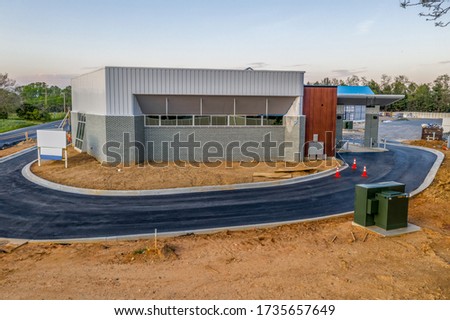 Aerial view of the back of a newly constructed bank branch commercial real estate building with drive through ATM lanes
