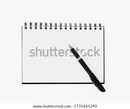 
Empty stylish spiral Notepad for notes and a beautiful corporate pen on a white background. Stylized stock photos. The view from the top.
