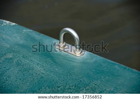 Close-up of a metal loop attached to a blue-green surface