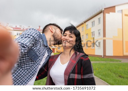 the Guy takes a selfie kissing his wife