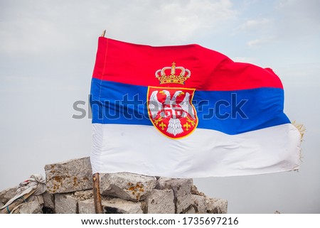 National flag of Serbia on the peak at mountain.