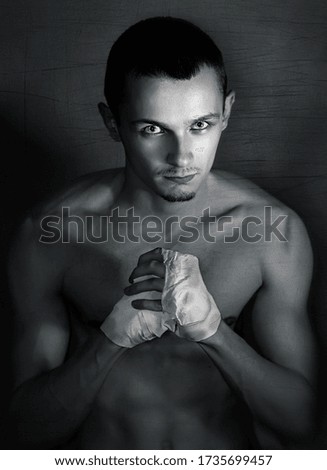 Serious young man boxer on dark background