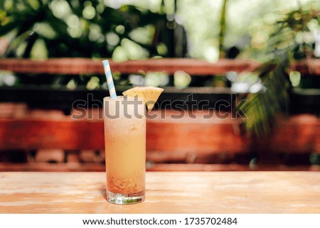 Smoothies of pineapple on the table with green background. Space for text.