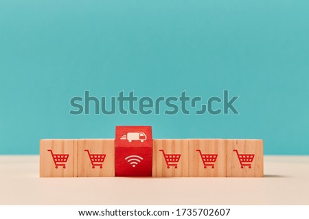 Online shopping. Express delivery service. E-shopping. E-store. Wooden cubes with one red. Trolley, truck, wifi signs