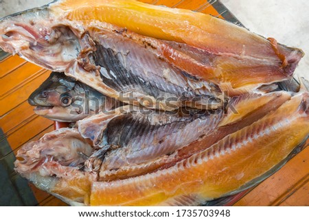 fresh, uncooked open fish on a wooden table