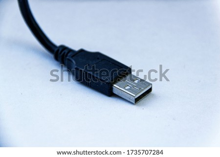 Black USB cable over a white background 