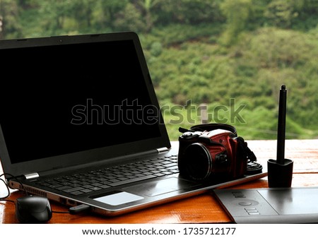 Camera on a laptop, around a mouse, a stylus pen and a digitizer tablet.