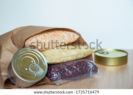 a set of delivery products, cereals and a tin can, on a wooden table