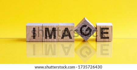 The word image is written on wooden cubes on a bright yellow background.