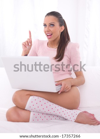 Young pretty women on white couch relaxing and using laptop computer