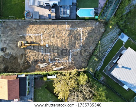aerial view of construction excavator working next to an already built villa