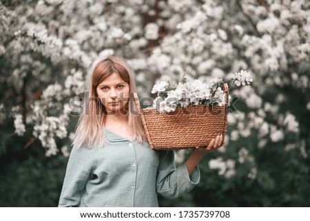 girl with a basket of flowers blooming Apple trees