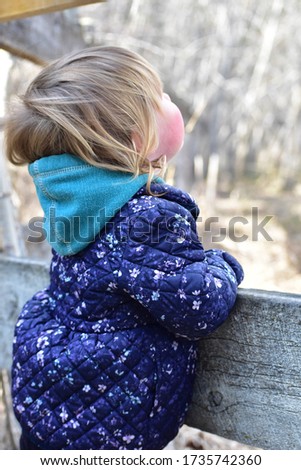 Young chid gazing in wonder in distance at nature in the park Royalty-Free Stock Photo #1735742360